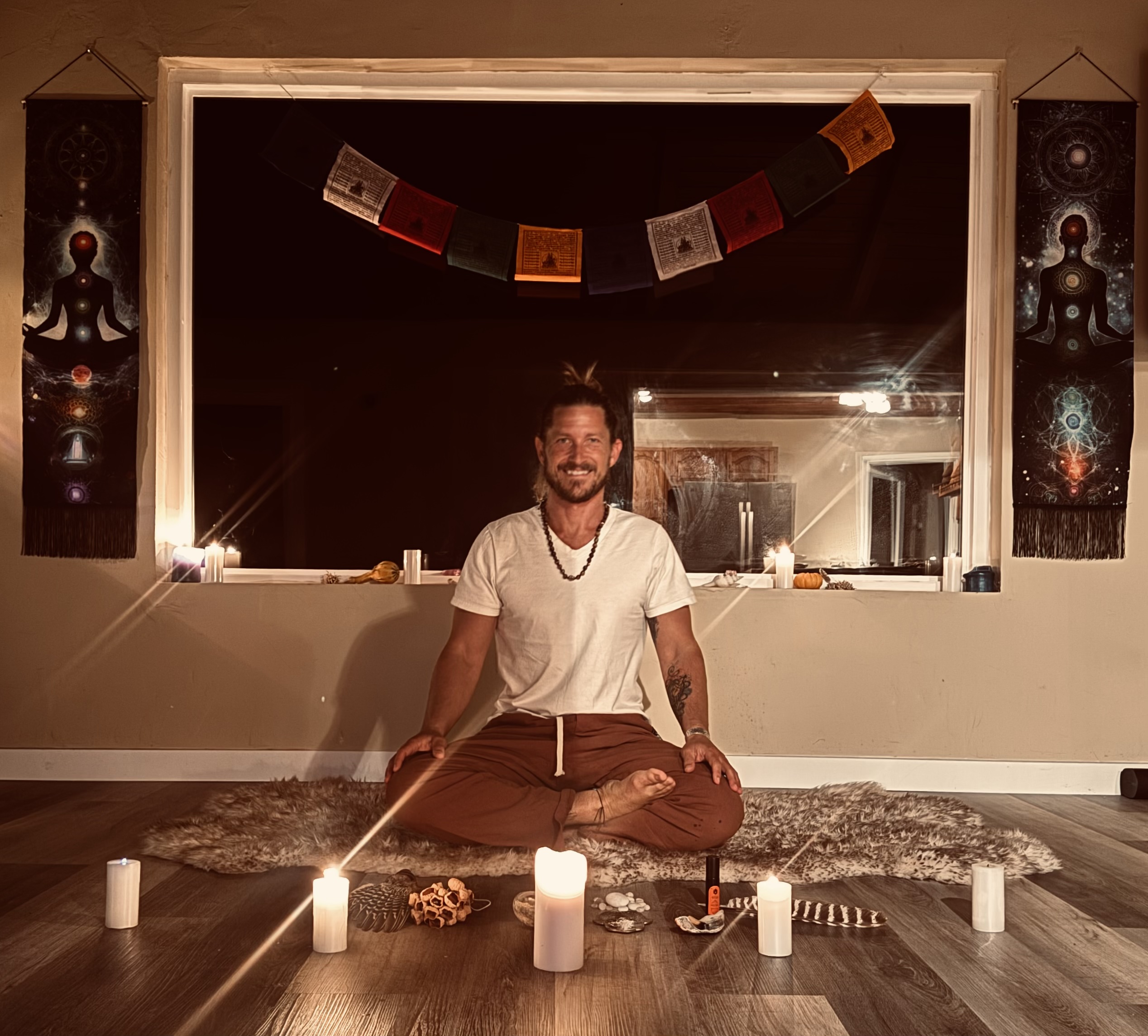 The founder in seated meditation, candles and prayer flags around him