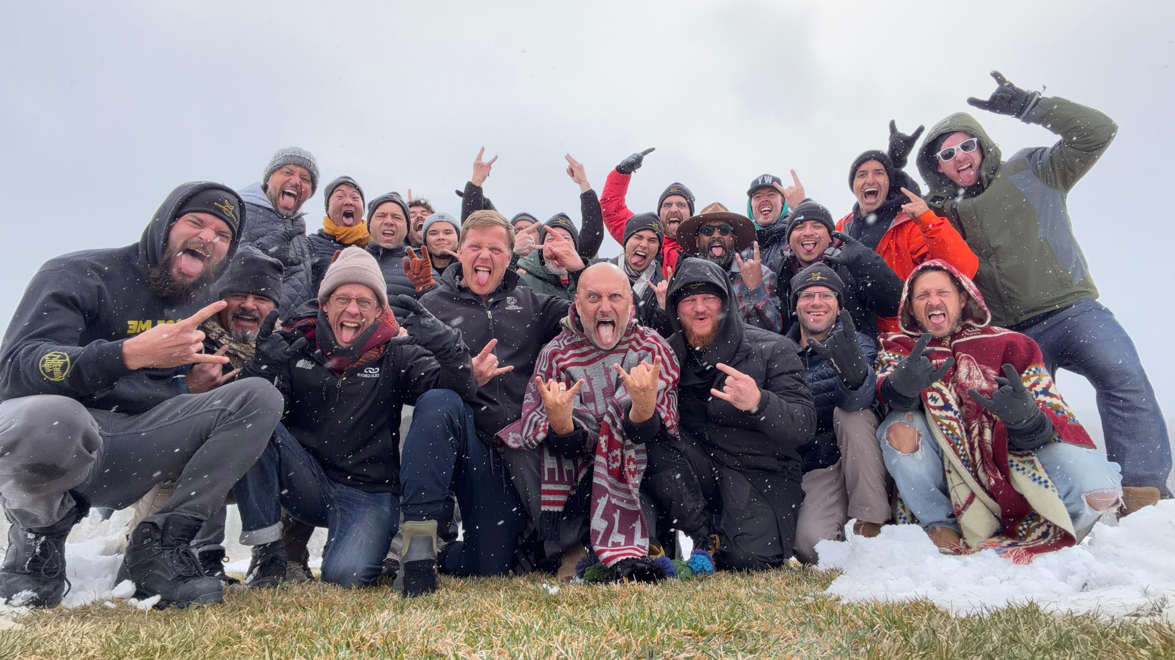 A large group of men celebrating together in the snow