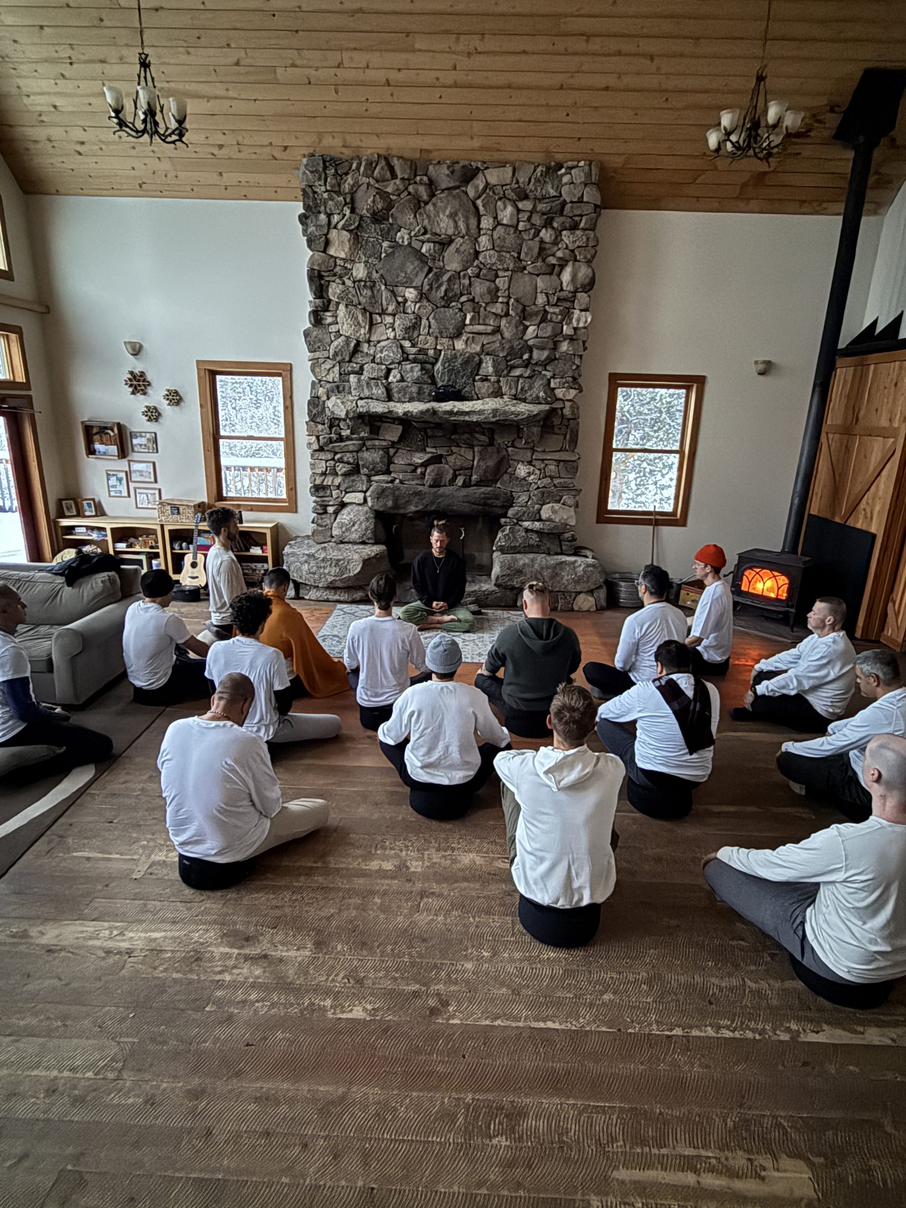A circle of men seated in training, a teacher at the front of the room