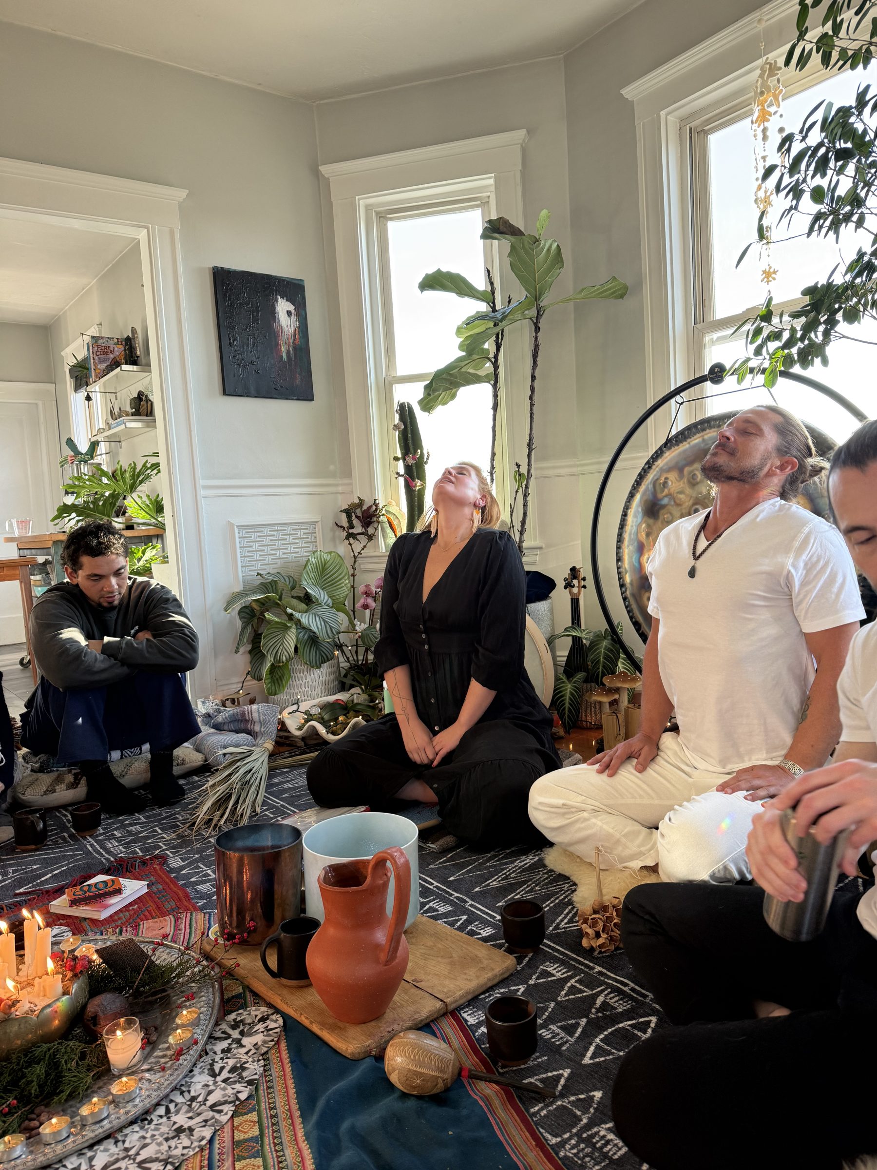 A sacred sharing circle indoors with gong, candles, and Moroccan rugs